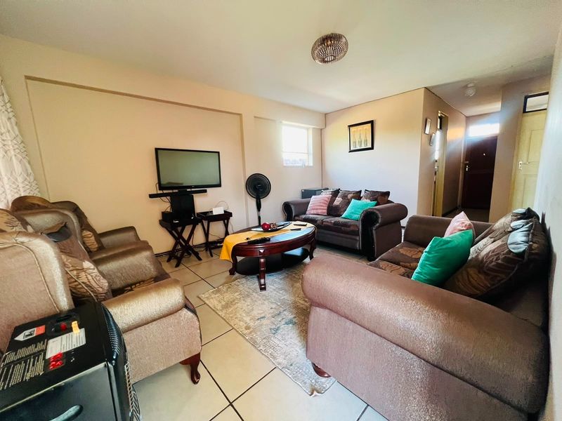 A living room featuring tiled flooring and neutral wall finishes, providing a functional space for relaxation and entertainment.
