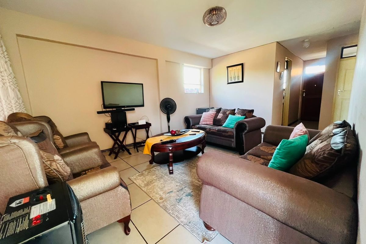 A living room featuring tiled flooring and neutral wall finishes, providing a functional space for relaxation and entertainment.