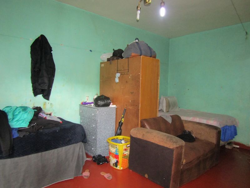 A bedroom space featuring painted walls in need of maintenance and repair.