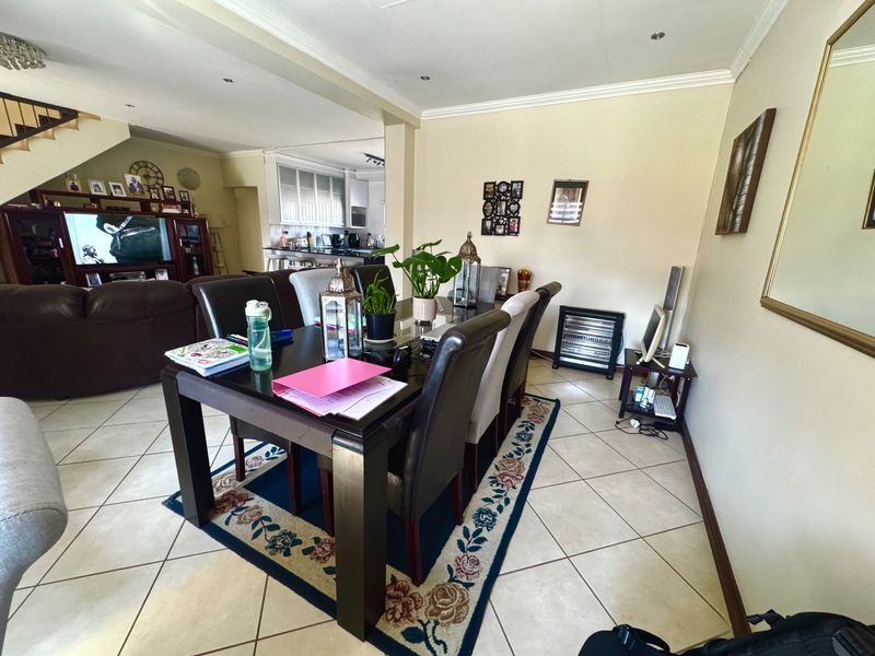 Spacious open-plan living and dining area featuring tiled flooring, recessed lighting, and a seamless flow into the adjacent kitchen space.
