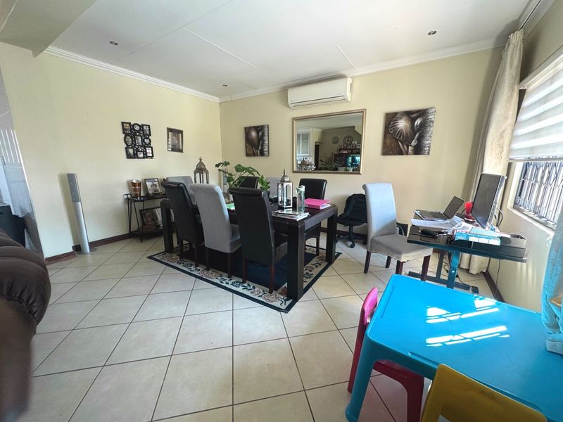Dining room featuring tiled flooring, recessed downlighting, and a wall-mounted air conditioning unit.