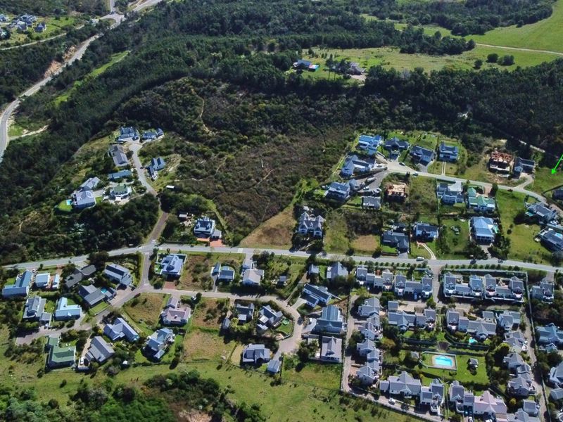 An aerial view of a residential estate showing the surrounding landscape, road infrastructure, and existing housing developments.