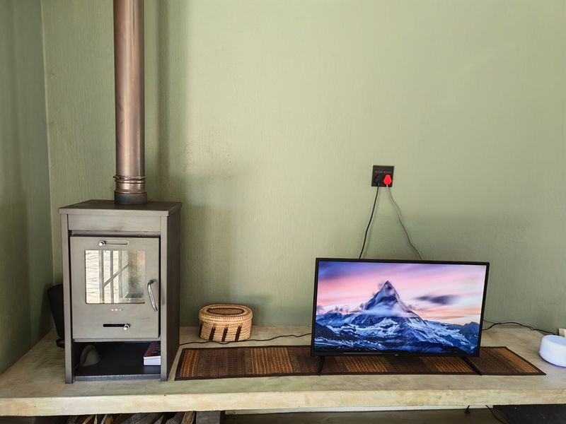 A living area featuring a built-in concrete hearth and a freestanding fireplace, providing a cozy focal point for the room.