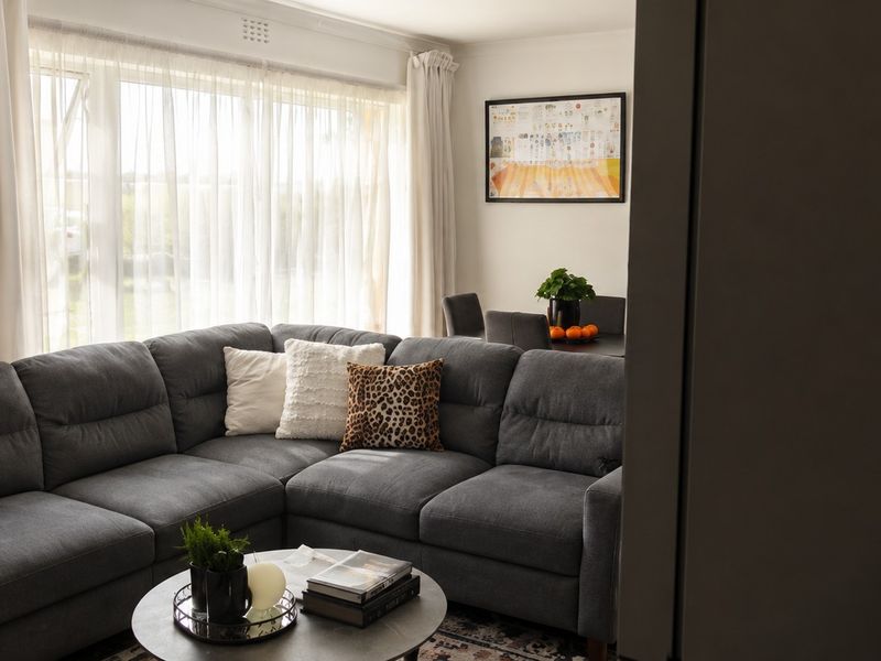 A comfortable living room featuring a large window with natural light, providing a bright and inviting atmosphere for relaxation.