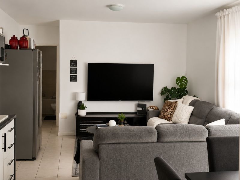 An open-plan living area featuring tiled flooring and integrated kitchen cabinetry, creating a functional and cohesive space.