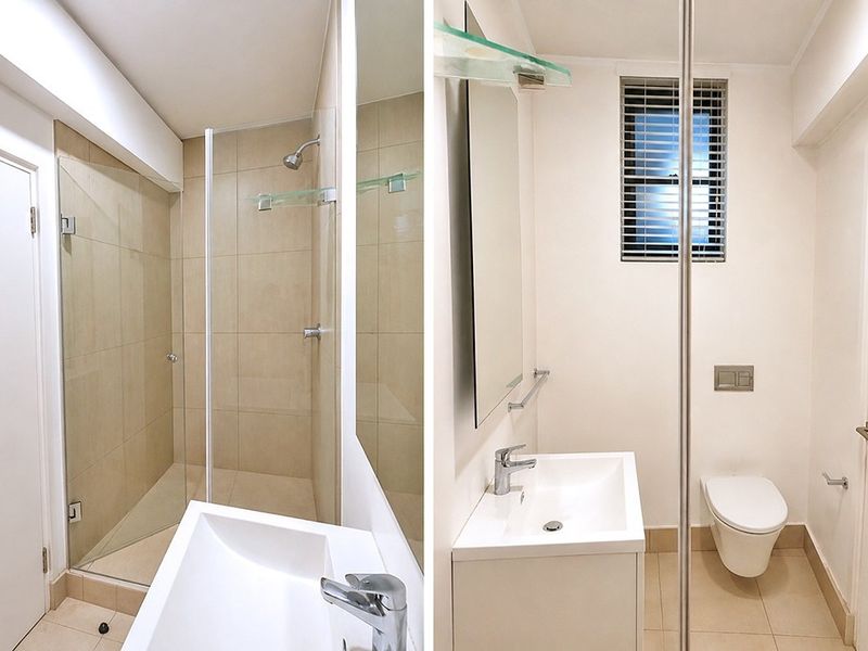 A modern, clean bathroom featuring a walk-in shower with glass screen, wall-hung toilet with concealed cistern, and a sleek vanity basin.