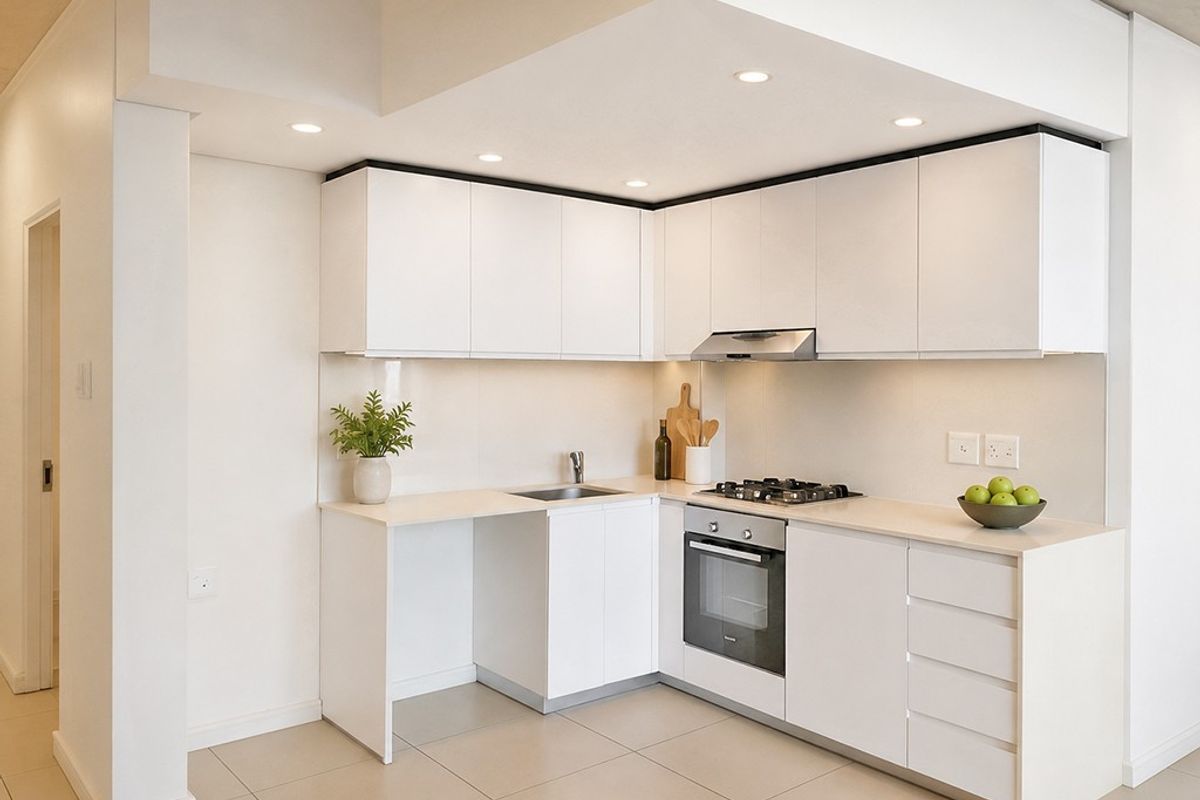 Modern kitchen featuring white cabinetry, integrated gas cooktop, built-in oven, extractor fan, and neutral tiled flooring in a clean, minimalist design.