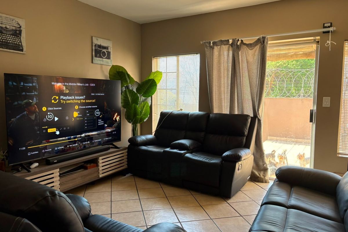 A comfortable living room featuring tiled flooring and a sliding glass door that provides access to the outdoor area.