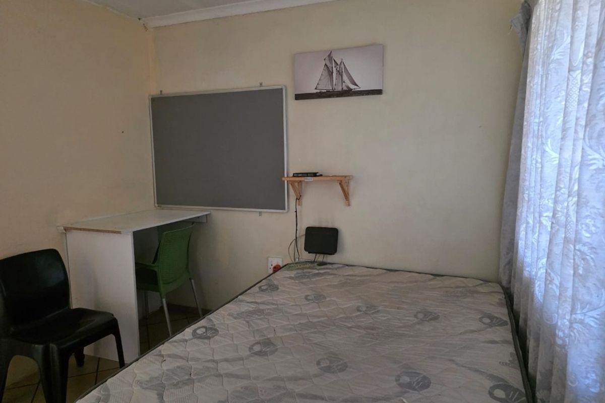 A compact bedroom featuring tiled flooring and neutral wall finishes, suitable for a single bed setup.