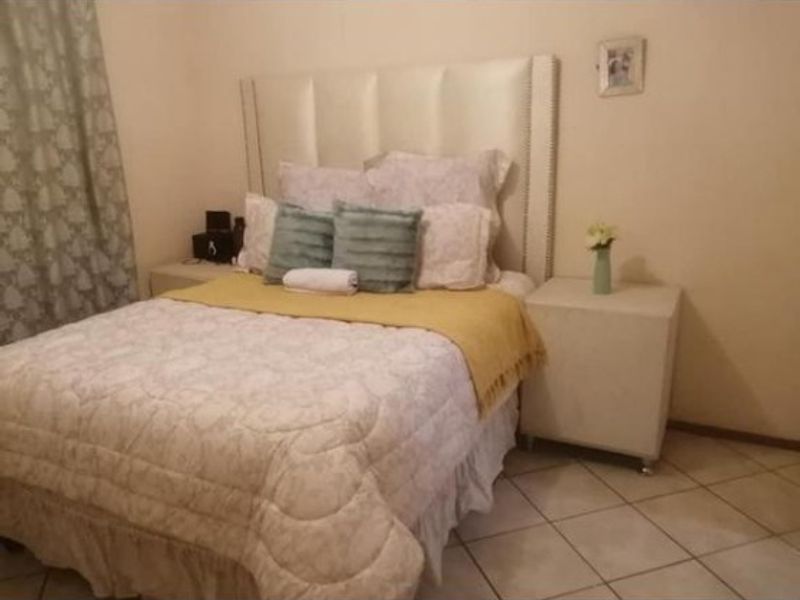A bedroom featuring tiled flooring and neutral wall finishes, providing a functional space for rest.