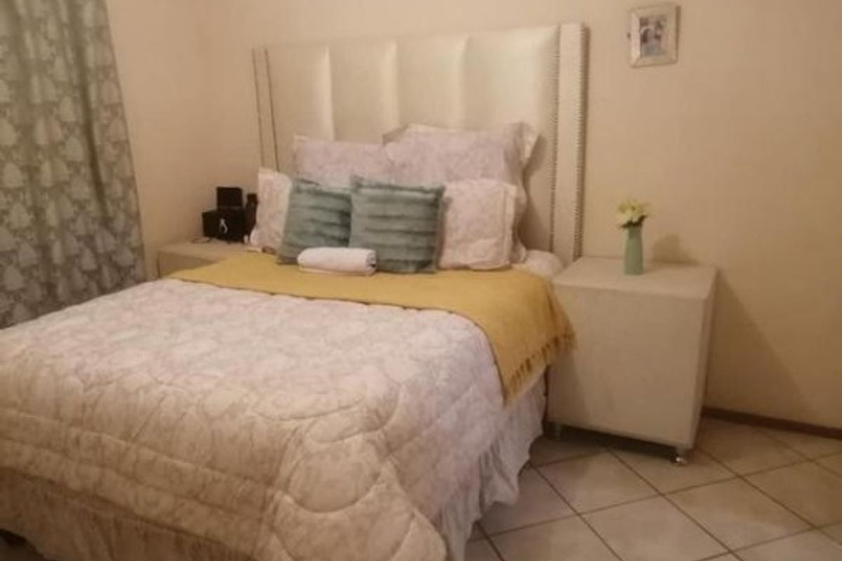 A bedroom featuring tiled flooring and neutral wall finishes, providing a functional space for rest.