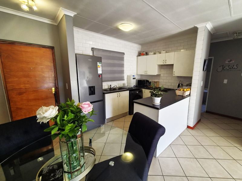 Open plan kitchen area featuring white subway tile backsplash, built-in cabinetry, laminate countertops, and ceramic floor tiles.