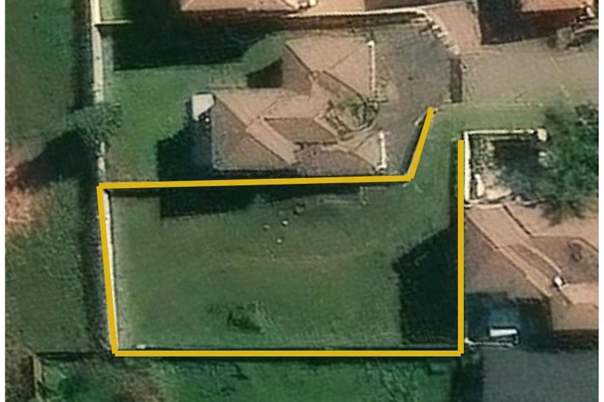 An aerial view of the property showing the building footprint and the demarcated garden area with boundary walls.