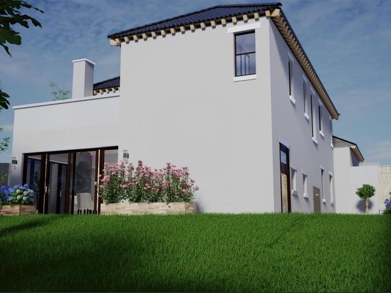 A rear view of a modern house featuring a tiled roof, chimney, and large sliding glass doors opening onto a landscaped garden area.