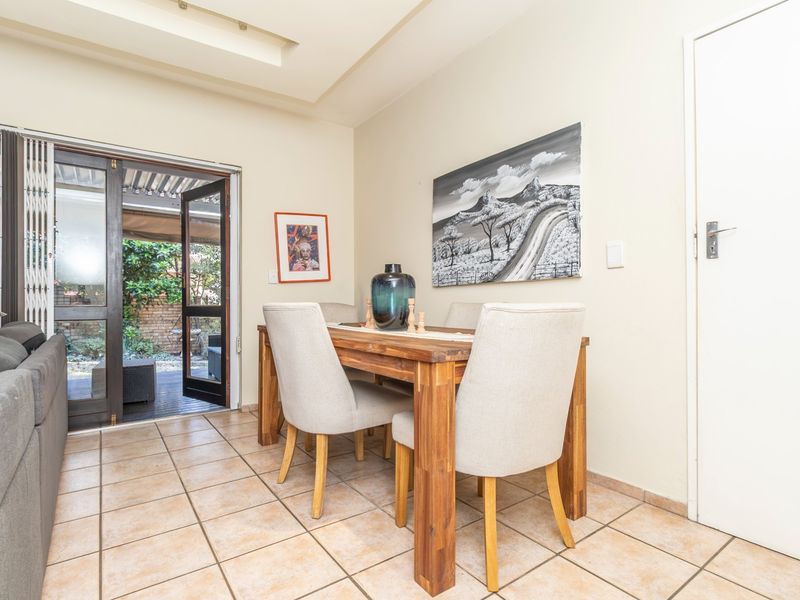 Dining area featuring tiled flooring and a recessed ceiling, with direct access to an outdoor patio through a sliding glass door.