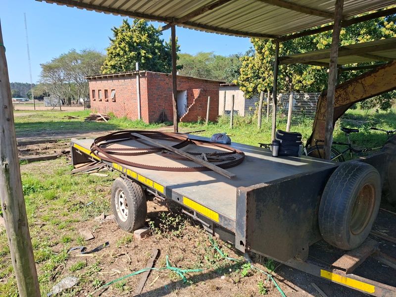 Outdoor area featuring a covered structure and a detached brick outbuilding in need of maintenance.