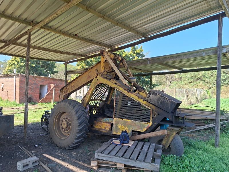 A covered outdoor utility area featuring a corrugated metal roof supported by timber posts, currently used for equipment storage.
