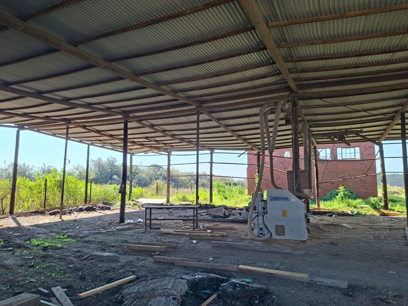 Open-plan industrial utility space featuring a corrugated metal roof, steel support structure, and an integrated dust extraction system on a concrete base.