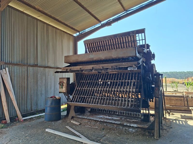 An industrial utility space featuring corrugated metal walls and roofing, housing heavy-duty machinery on a concrete floor.