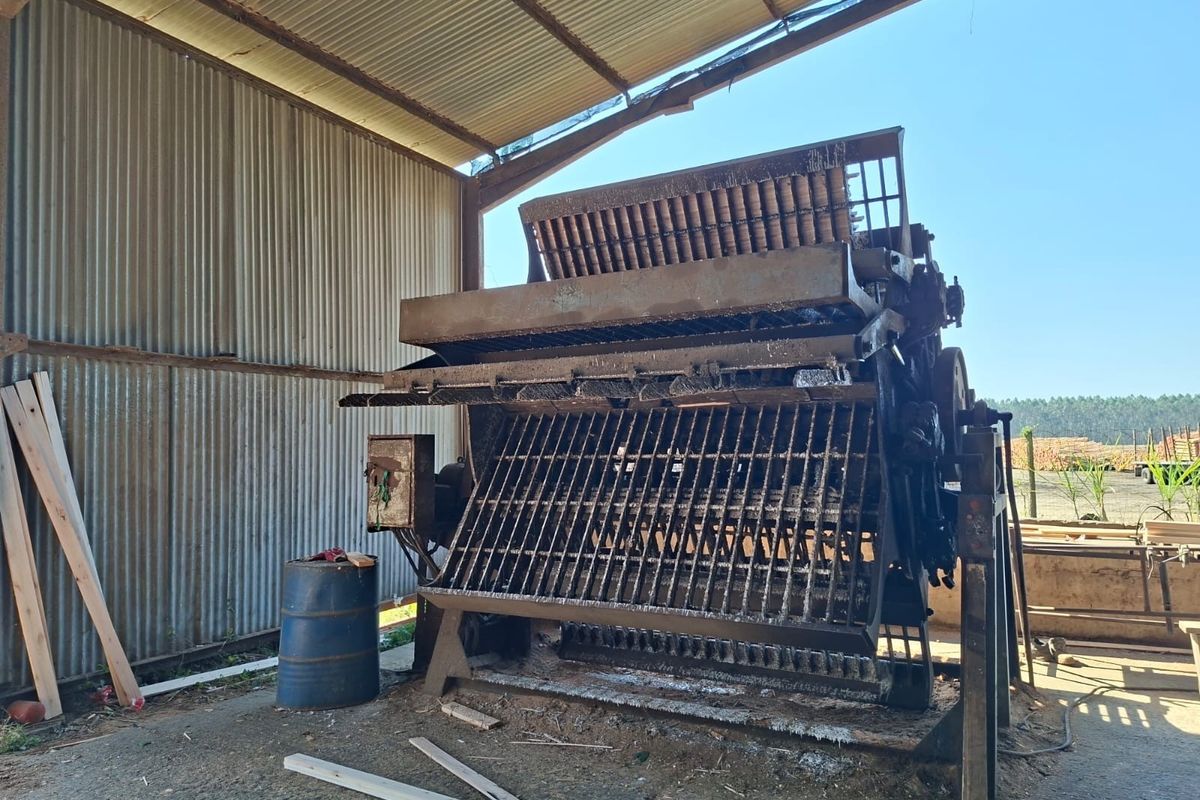 An industrial utility space featuring corrugated metal walls and roofing, housing heavy-duty machinery on a concrete floor.