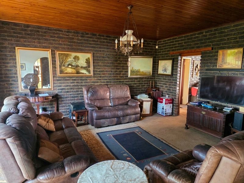A living room featuring exposed brick walls and a timber tongue and groove ceiling, providing a rustic aesthetic.