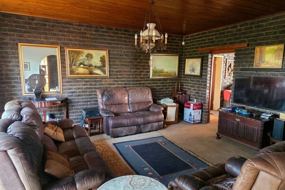 A living room featuring exposed brick walls and a timber tongue and groove ceiling, providing a rustic aesthetic.