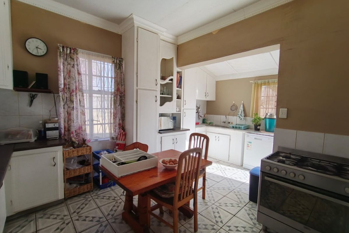 A functional kitchen featuring built-in cabinetry, a gas stove, and tiled flooring, offering a practical layout with potential for modern updates.