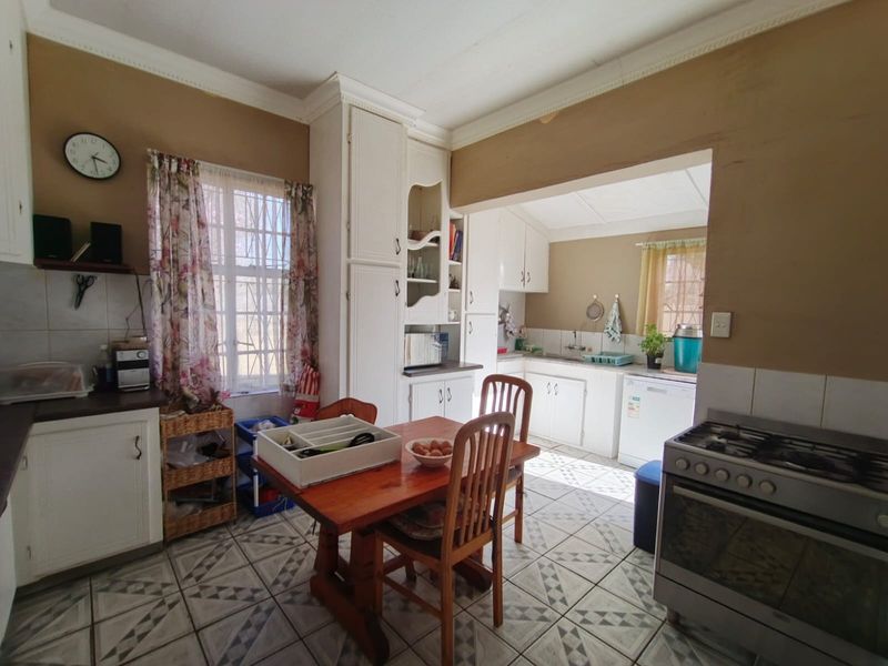 A functional kitchen featuring built-in cabinetry, a gas stove, and tiled flooring, offering a practical layout with potential for modern updates.