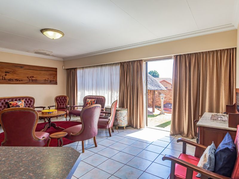 Spacious living area featuring tiled flooring, coved ceilings, and direct access to the outdoor patio through a sliding glass door.