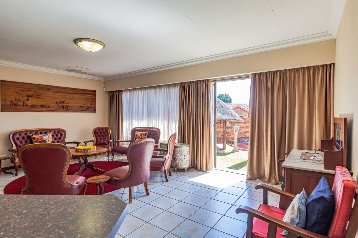 Spacious living area featuring tiled flooring, coved ceilings, and direct access to the outdoor patio through a sliding glass door.