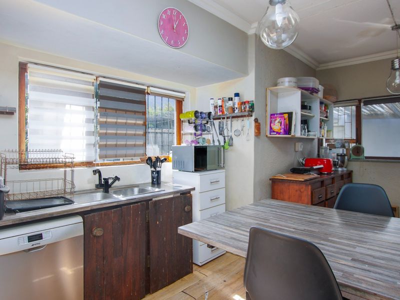 A functional kitchen space featuring a stainless steel sink, integrated dishwasher, and laminate countertops, offering potential for modernization and aesthetic improvement.