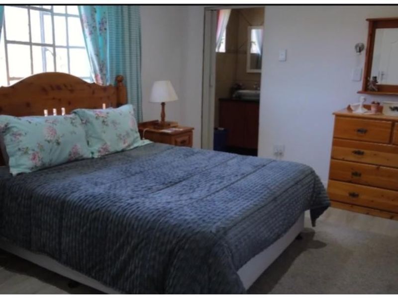 A standard bedroom featuring a window and an adjoining doorway leading to an en-suite bathroom.