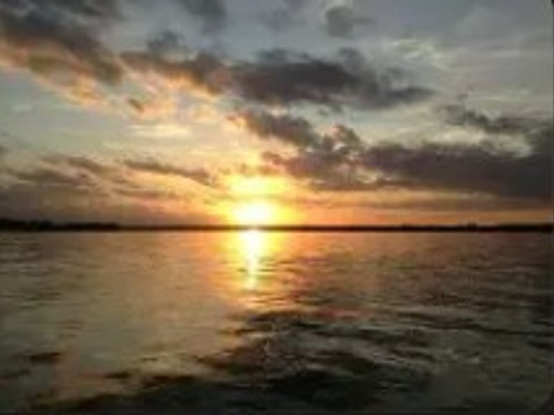 A scenic sunset view over a body of water, highlighting the natural landscape surrounding the property.