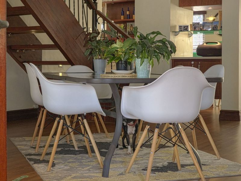 Dining area featuring a wooden staircase with wrought iron balustrade and adjacent built-in cabinetry, set against a neutral interior backdrop.