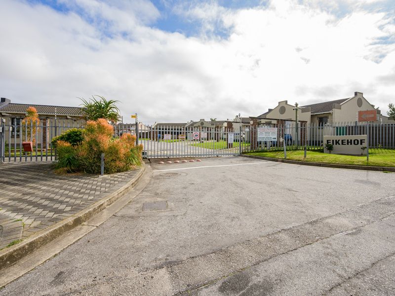Front entrance view of Eikehof complex featuring secure automated gate access, perimeter fencing, and paved driveway.
