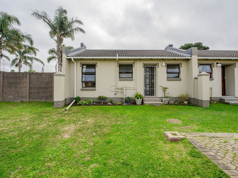 Rear view of the property featuring a private garden, paved patio area, and secure access point with a tiled roof finish.