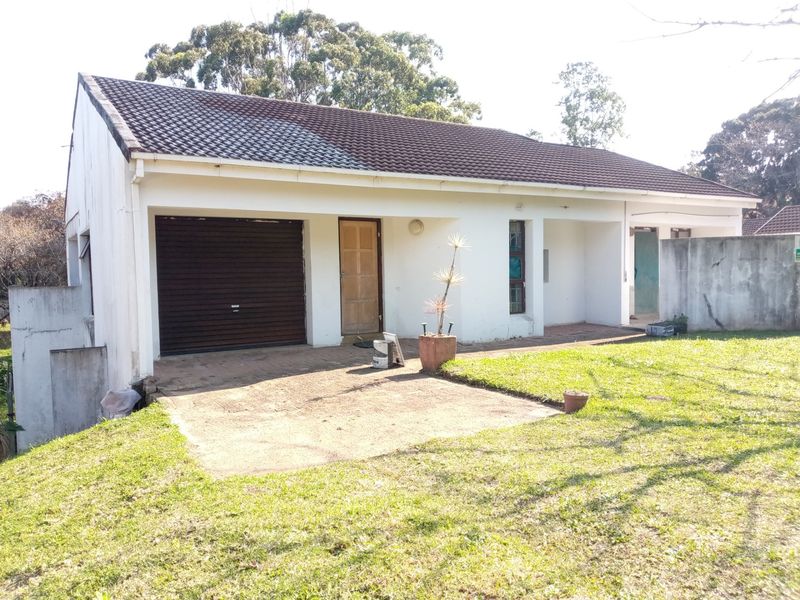 Front exterior view of a single-story house featuring a tiled roof, integrated garage, and paved driveway area.