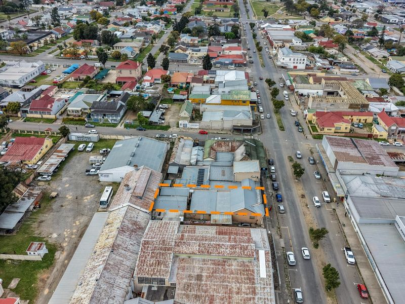 Aerial view of a commercial property located in a dense urban area, highlighting the building's roof structure and surrounding street network.