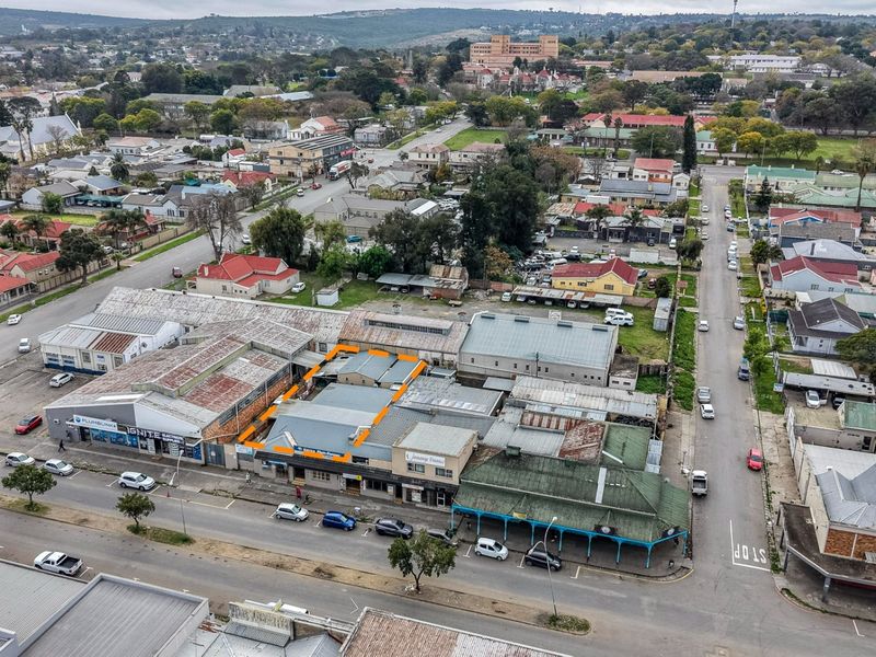 Aerial view of a commercial property block featuring corrugated metal roofing, situated in a central urban street location with surrounding infrastructure.