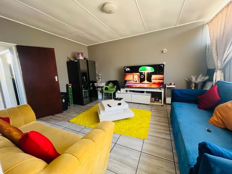 A living room featuring tiled flooring and a standard ceiling, providing a functional and comfortable space for relaxation.