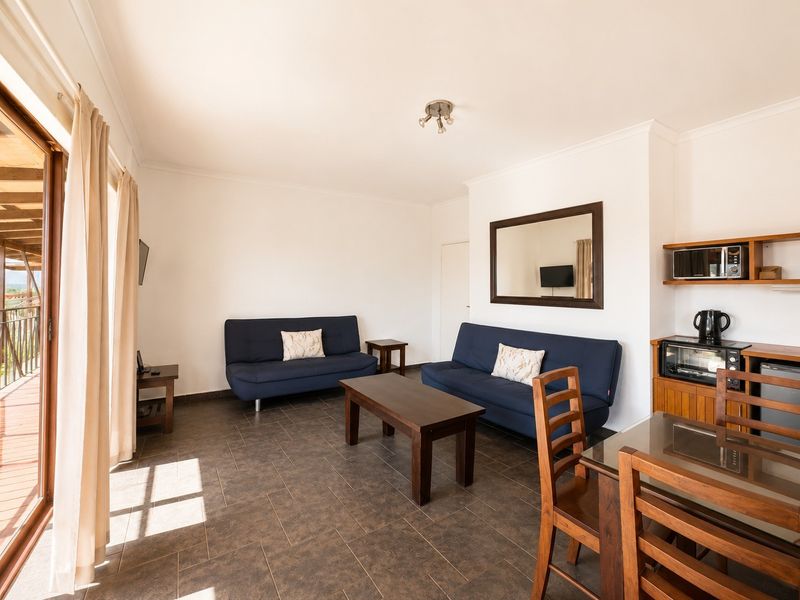 Open-plan living and dining area featuring tiled flooring and direct access to an outdoor balcony through sliding glass doors.