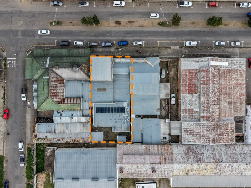 Aerial view of the property highlighting the roof structure and installed solar panels within the urban commercial context.