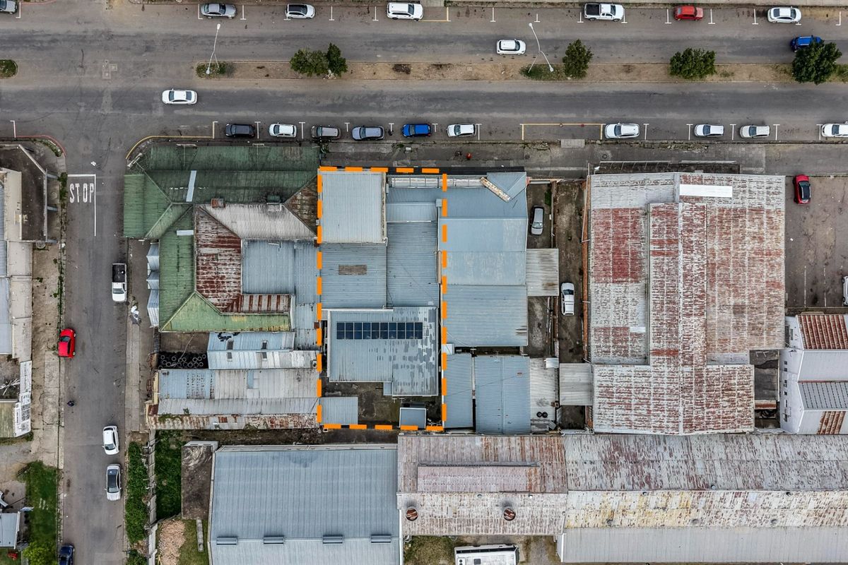 Aerial view of the property highlighting the roof structure and installed solar panels within the urban commercial context.