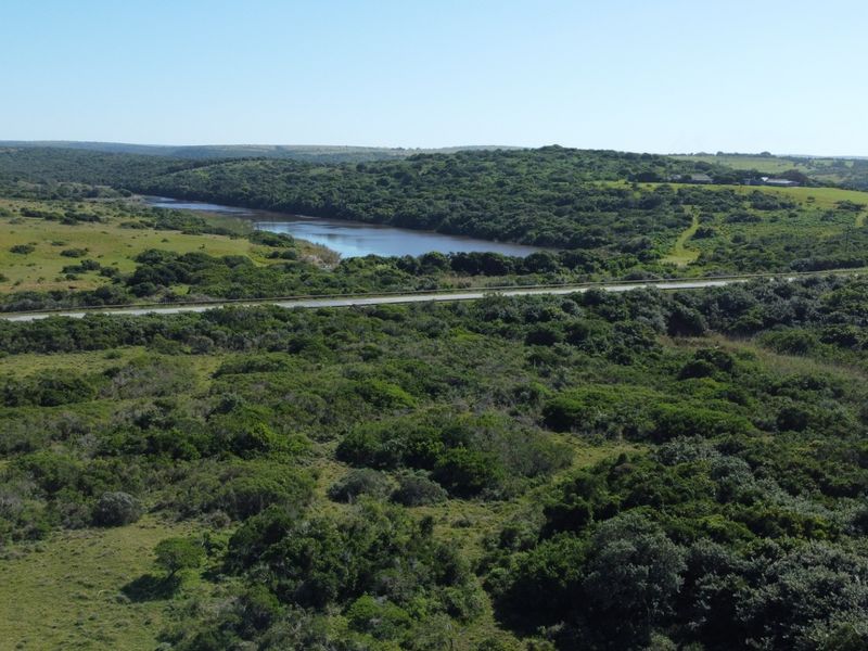An aerial view of the expansive rural property featuring natural vegetation and a scenic river flowing through the landscape.