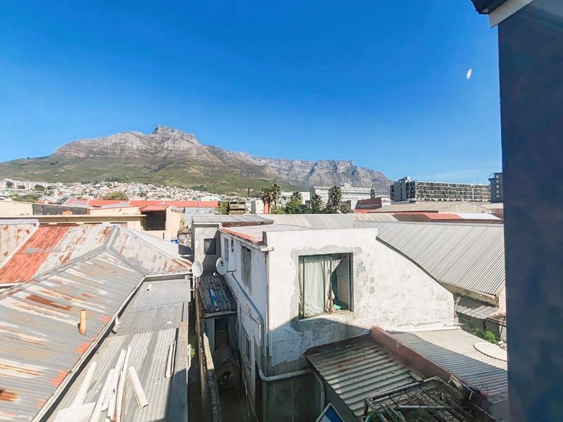Elevated view overlooking surrounding urban rooftops with a prominent mountain backdrop.
