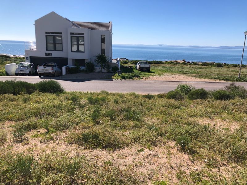 A vacant residential plot offering prime coastal views, situated in a developed neighborhood with direct road access.