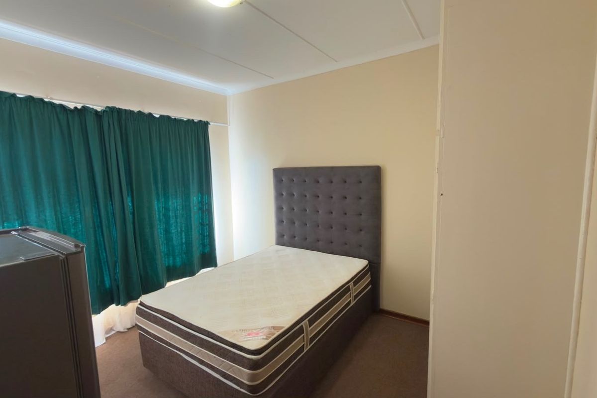 A functional bedroom featuring carpeted flooring and a built-in cupboard, offering a neutral canvas for potential interior updates.