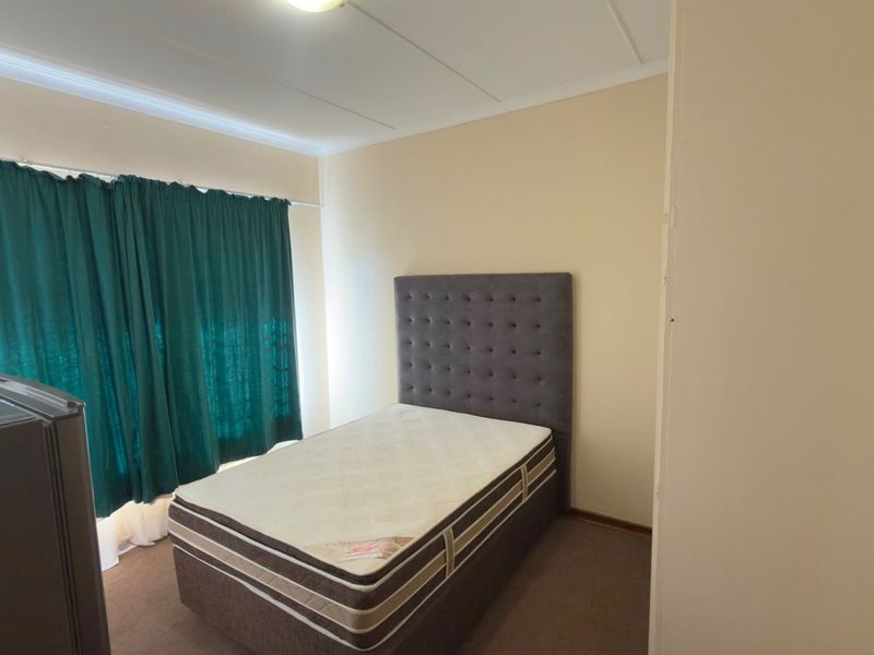 A functional bedroom featuring carpeted flooring and a built-in cupboard, offering a neutral canvas for potential interior updates.