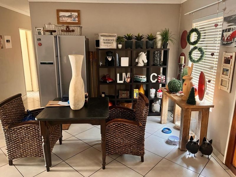 Open plan living area featuring tiled flooring and venetian blinds, providing a functional space for dining or casual seating.
