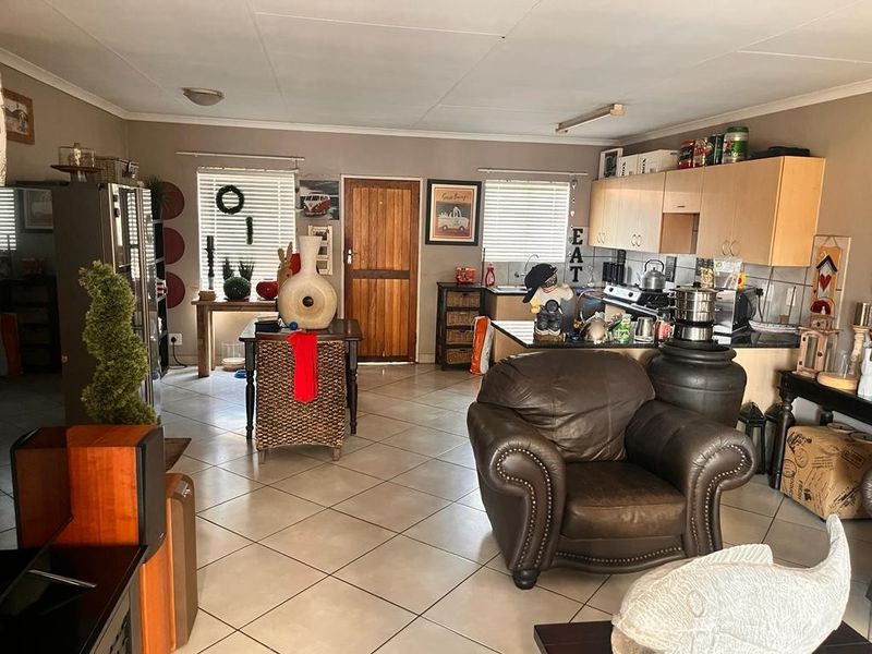 Open plan living and kitchen area featuring tiled flooring and functional built-in cabinetry.